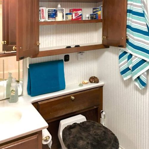 Toilet and Stocked Cabinet